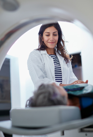 Elderly woman being comforted by a female doctor before an MRI.