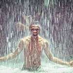 Man under a waterfall.